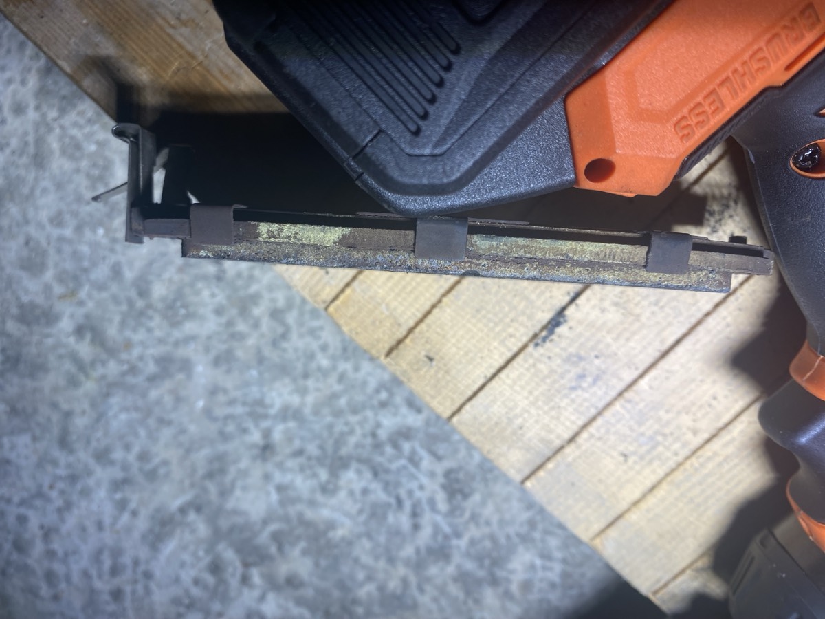 Side profile of worn pad showing thin sliver of material against backing plate