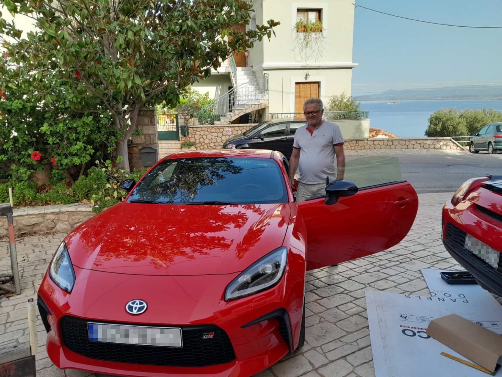 Father next to the GR86 with the sea in the background