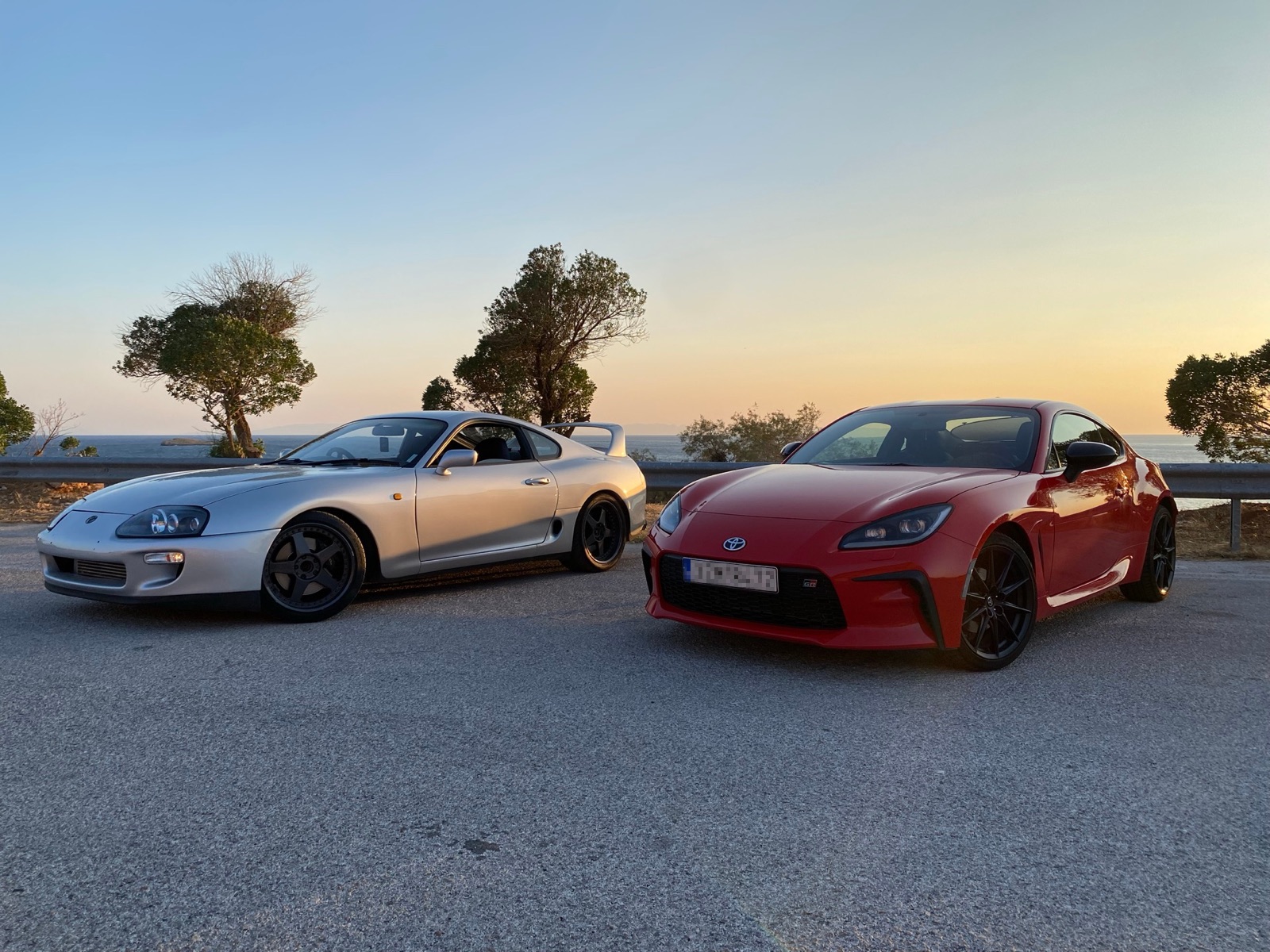 Supra and GR86 side by side at sunset, facing camera