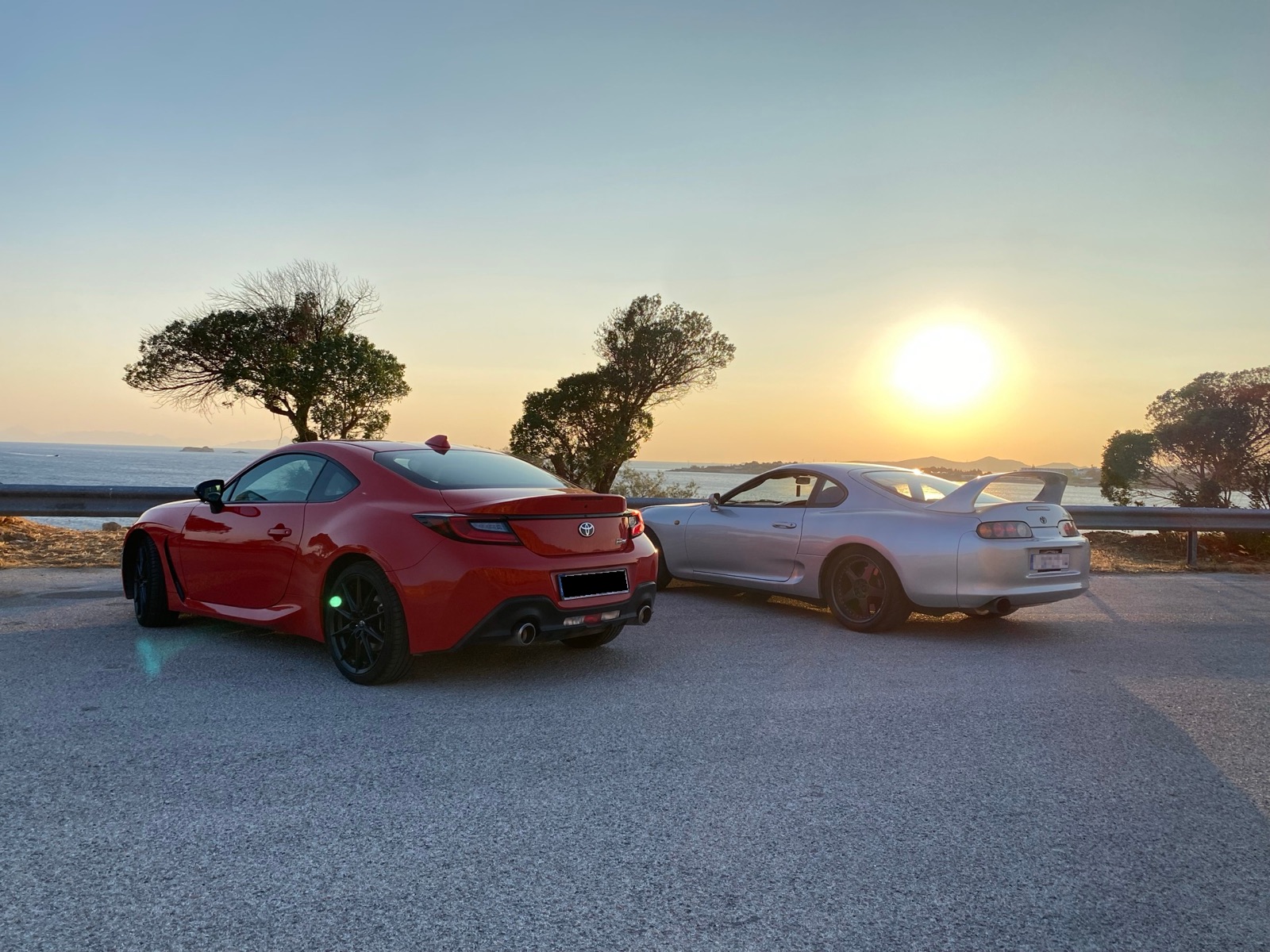 GR86 and Supra rear view at sunset over the sea