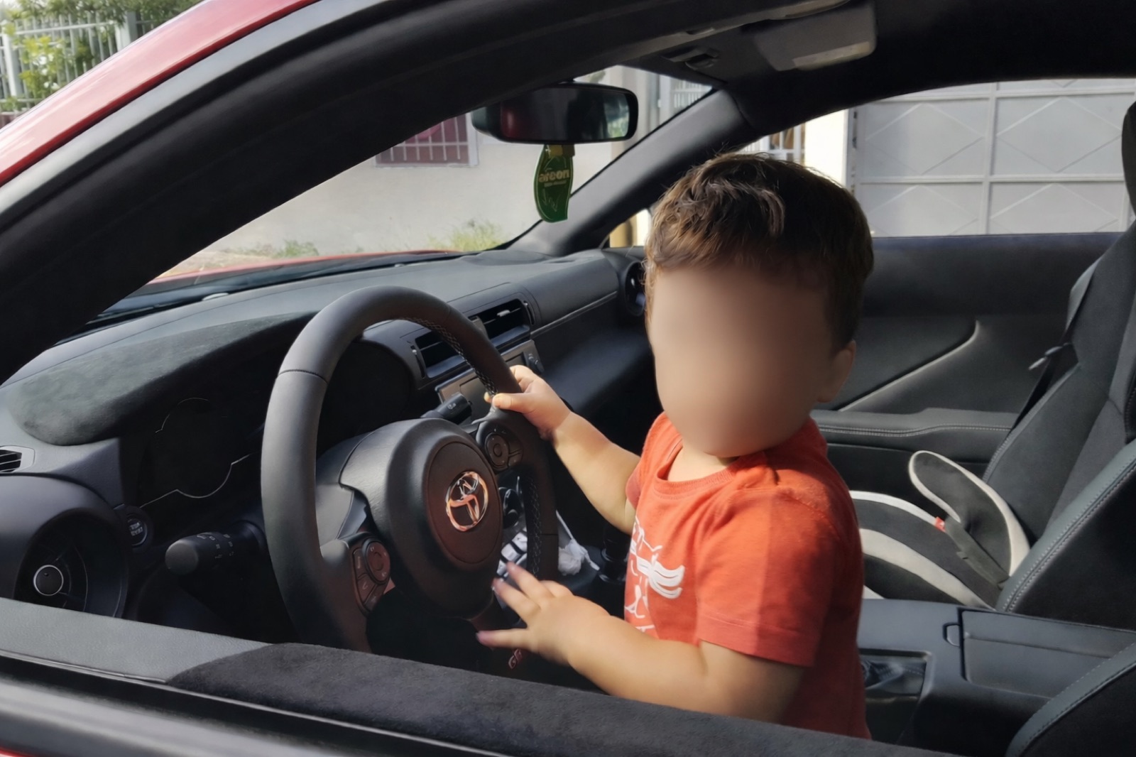 Toddler gripping the GR86 steering wheel